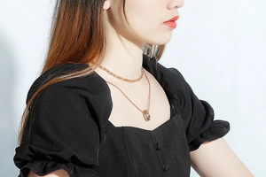 Close-up of double-layer rose gold necklace with round pendant on model