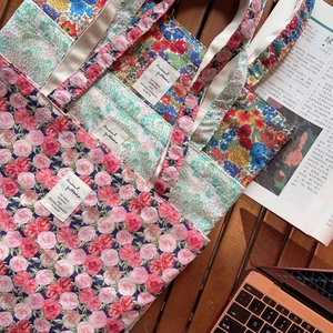 Detailansicht von Stofftaschen mit floralen Vintage-Mustern und Reliefstruktur.