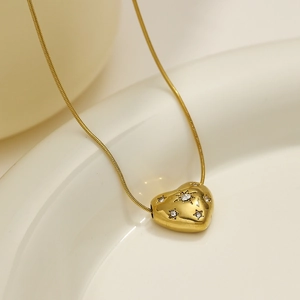 Golden heart pendant necklace with starburst diamonds on a sleek snake chain