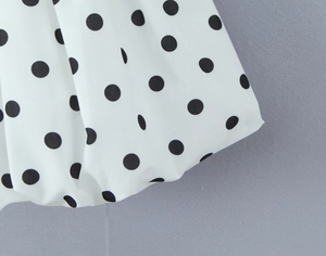 Vue macro détaillée du tissu en mousseline blanche à pois noirs avec texture plissée douce