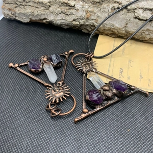 Detail of vintage bronze solar amethyst triangle pendant with natural crystal point