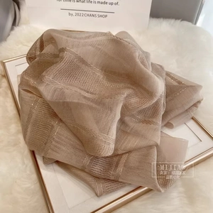 Close-up of champagne silk wool scarf with metallic gold stripes and sheer texture