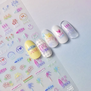 Detail of thin summer beach nail stickers featuring sunset, surf and coconut tree designs