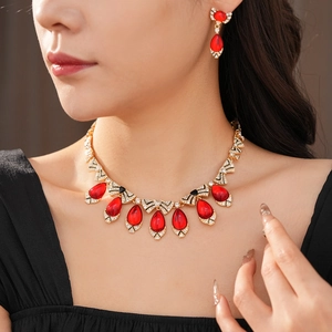Detailed close-up of a vintage jewelry set with red teardrop stones and bow tie accents