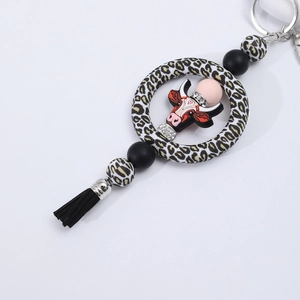Detail of cartoon bull keychain with leopard print silicone beads and a black silk tassel