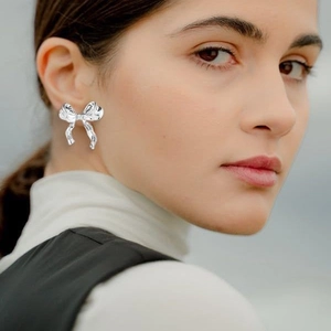 Polished silver bow earrings for women featuring a minimalist and fluid metal design