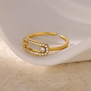 18K gold plated safety pin ring with shimmering zircon crystals on white plate
