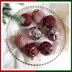 Detail of red and pink mesh Christmas ornaments with fabric texture in a glass dish