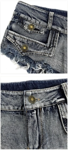 Dettaglio macro di pantaloncini di denim blu con bottoni di bronzo e orli sfrangiati
