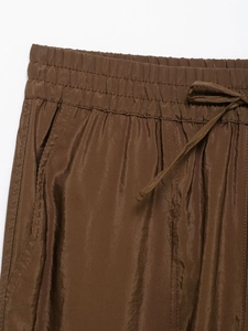 Detail of dark brown elastic waistband with drawstring and side pocket on leisure pants