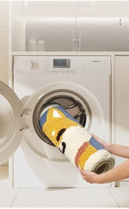 Detail of Shiba Inu bath mat showing machine washable feature in a front-load washer