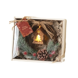 Illuminated Christmas wreath gift box with wooden house, pine cones and red berries