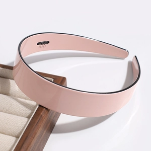 Detail of pink hairband with inner comb teeth and black edge on jewelry tray