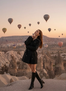 Détail de la robe blazer noire cintrée portée avec des bottes hautes en cuir élégantes