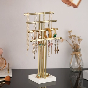 Golden 4-tier T-bar jewelry stand with white base displaying necklaces and earrings
