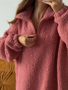 Close-up of pink sherpa fleece texture and half-zip collar on warm winter sweatshirt