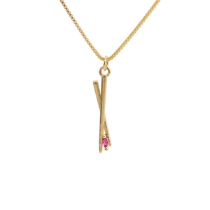 Detail of gold-plated box chain necklace with crossed chopsticks and pink zircon pendant