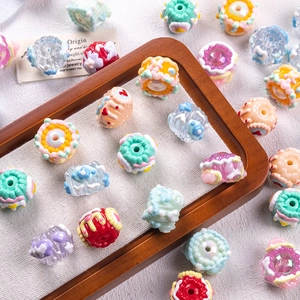Close-up of colorful candy-shaped acrylic beads for DIY jewelry making on a wooden tray