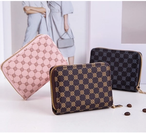Three mini wallets with diamond clover prints and metal zippers in stylish arrangement