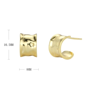 Macro detail of gold C-shape hoop earrings showing hammered texture and 10.5mm x 8mm dimensions