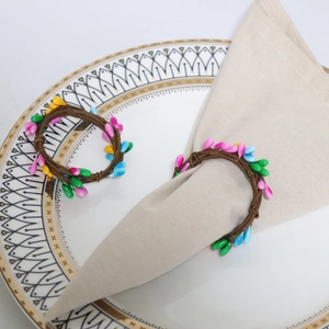 Close-up of colorful berry bead napkin rings on a rustic woven band for Easter table decor