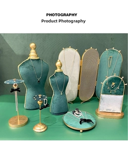 Detail of dark green velvet jewelry display set with gold metal accents for photography
