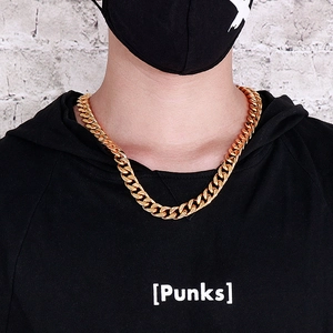 Detailed street style shot of a thick 18K gold-plated cuban link necklace on a male model