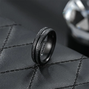 Close-up of black matte titanium steel ring with polished groove on leather