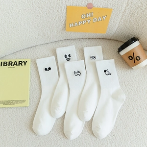 Five-pack set of white cotton socks with cute emoji embroidery on a cozy background