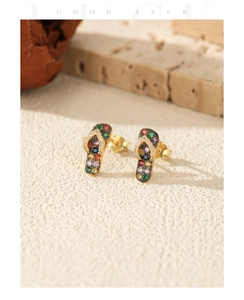 Macro shot of colorful zircon-studded flip-flop stud earrings on a stone base