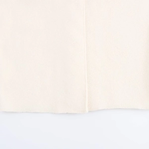 Detailed macro view showing the beige wool fabric texture and hem stitching on the coat