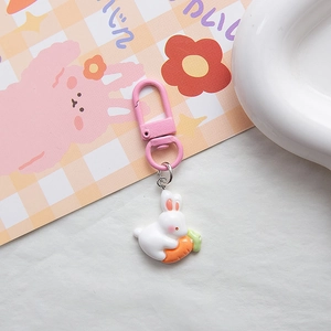 Close-up of pink carrot bunny keychain with white resin rabbit and orange carrot charm