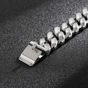 Détail macro du bracelet gourmette en argent poli avec fermoir et texture métallique