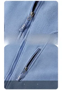 Detail of durable metal zipper and chest pocket on blue fleece utility vest jacket