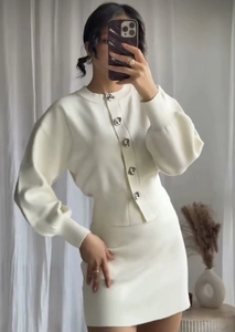 Detalle del conjunto de dos piezas de punto blanco con cárdigan y minifalda