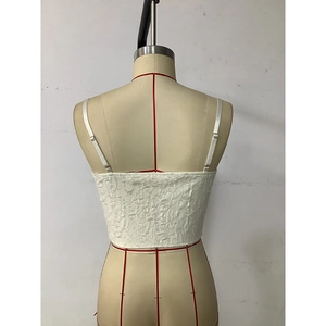 Detail of white textured fabric and button closure on the back of this crop camisole