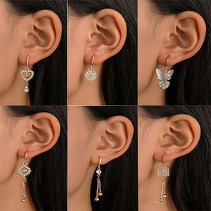 Detailed view of vintage gold and silver wing earrings with intricate carved textures