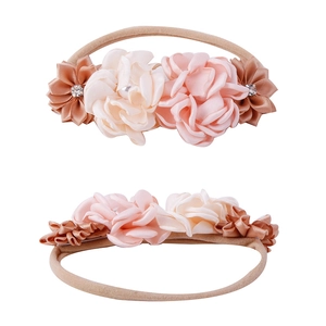 Macro view of handmade floral baby headband with nylon band and rhinestone centers