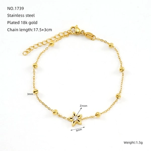 Détail d'un bracelet en acier inoxydable plaqué or 18K avec fleur en zircon et perles