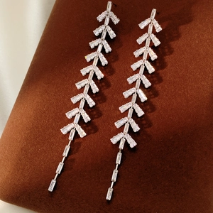 Macro shot of silver tassel earrings with zircon leaf design and hanging chains
