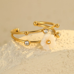 Detail of 18K gold titanium steel bangle featuring a white flower and sparkling crystals