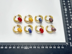Flat lay of gold hoop earrings with colorful round beads and measurement ruler