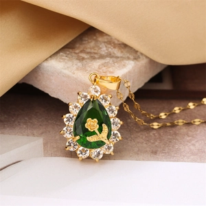 Detail of teardrop green gem pendant with gold rose inlay and sparkling zircon border