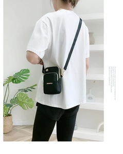 Rear view of a model wearing the black multi-layer nylon crossbody mobile phone bag