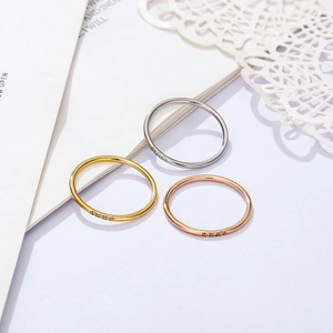 Detail of 18k minimalist rings with three micro-paved zircons in gold, silver, and rose gold