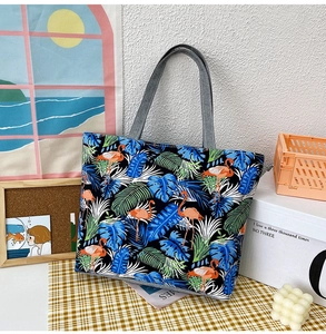 Detail of canvas tote bag with tropical flamingo and leaf print on black background