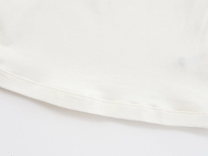 Close-up of the fine double-needle stitching on the hem of a white fitted knit t-shirt