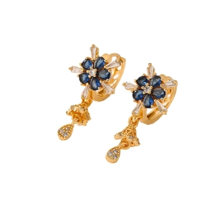Elegant gold flower earrings with blue and clear zircon stones on a white background