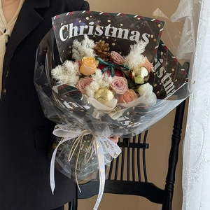 Christmas bouquet with roses and pine cones wrapped in Merry Christmas kraft paper