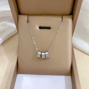 Detail shot of silver titanium steel choker necklace with Roman numeral triple ring pendant